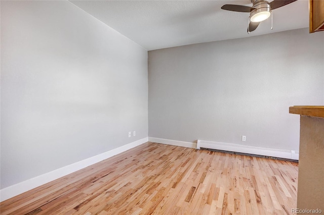 unfurnished room with ceiling fan, a baseboard radiator, and light hardwood / wood-style flooring