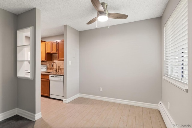 kitchen with sink, a baseboard heating unit, white dishwasher, light hardwood / wood-style floors, and decorative backsplash