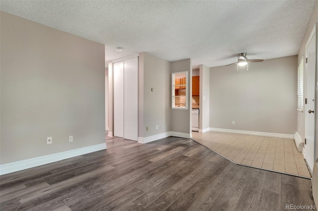 unfurnished room featuring a baseboard heating unit, hardwood / wood-style floors, a textured ceiling, and ceiling fan