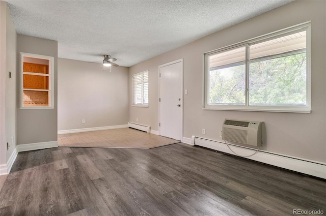 foyer with an AC wall unit, hardwood / wood-style floors, a textured ceiling, and baseboard heating