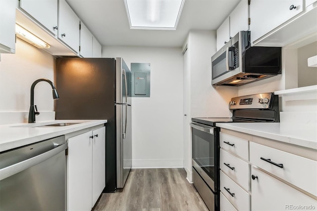 kitchen featuring white cabinets, light wood-type flooring, sink, and appliances with stainless steel finishes