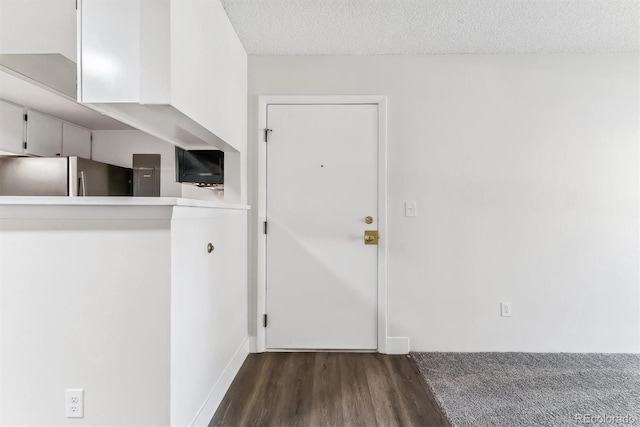 interior space with a textured ceiling and dark wood-type flooring