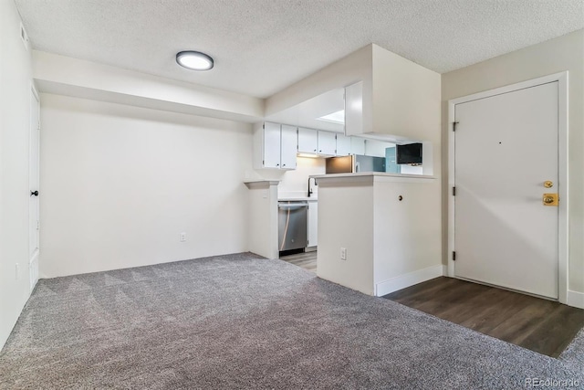 kitchen featuring kitchen peninsula, a textured ceiling, white cabinetry, and stainless steel dishwasher