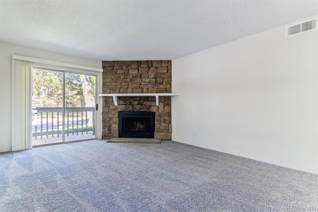 unfurnished living room featuring a textured ceiling, carpet flooring, and a fireplace