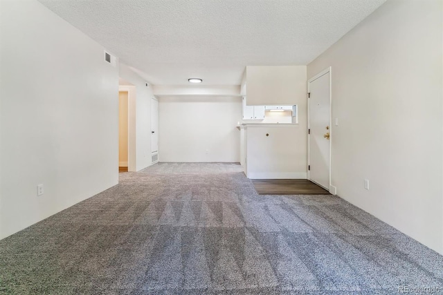 carpeted empty room featuring a textured ceiling