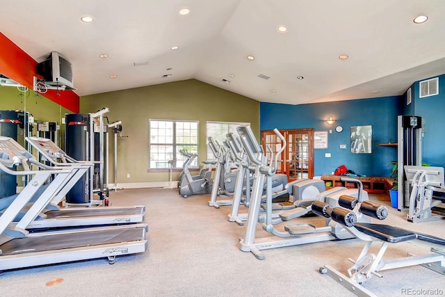 exercise room with light carpet and vaulted ceiling