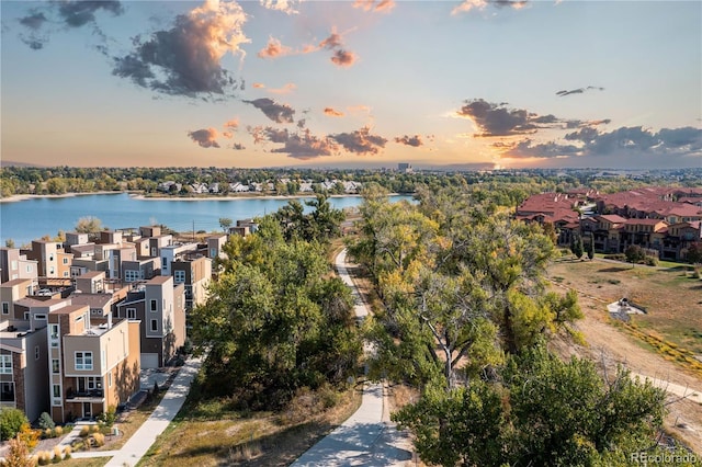 aerial view at dusk featuring a water view