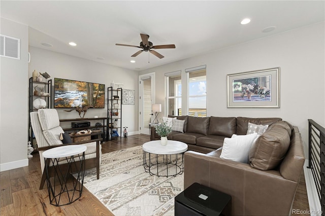 living room featuring ceiling fan and dark hardwood / wood-style floors