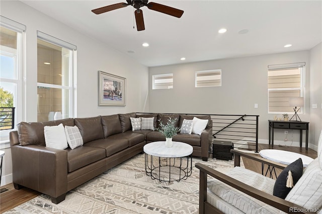 living room featuring ceiling fan, plenty of natural light, and light hardwood / wood-style floors