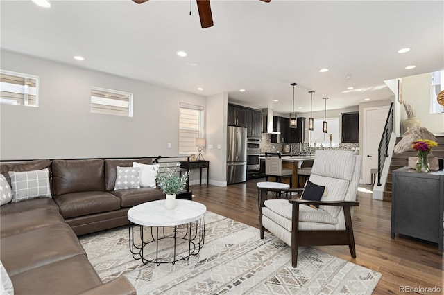 living room with plenty of natural light, light wood-type flooring, and ceiling fan