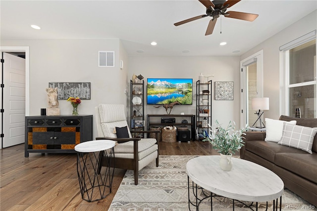 living room with wood-type flooring and ceiling fan