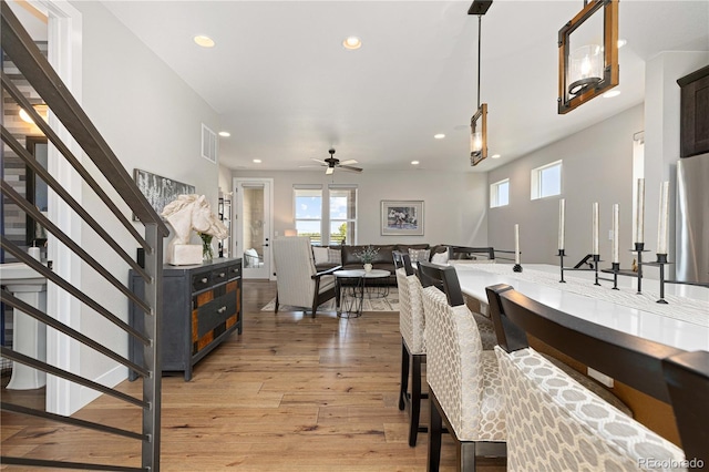 dining room with ceiling fan and light hardwood / wood-style flooring