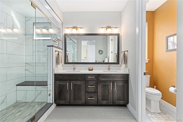 bathroom featuring vanity, toilet, a shower with door, and tile patterned floors