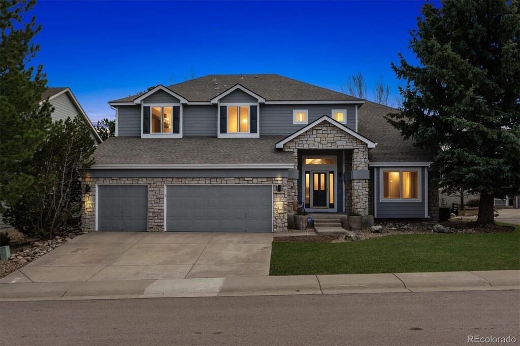 598 Stonemont Dr, Castle Pines, CO 80108 - view of front of house with concrete driveway, an attached garage, stone siding, and a shingled roof