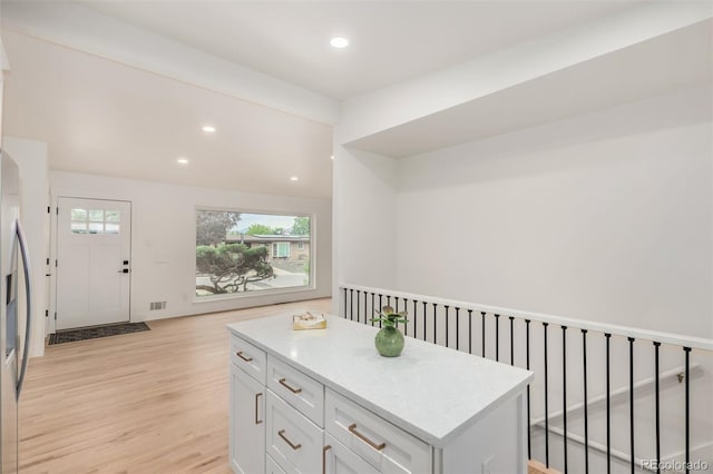 1948 S Zenobia St, Denver, CO 80219 - kitchen featuring light wood-style floors, white cabinetry, light countertops, recessed lighting, and a kitchen island