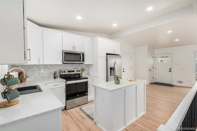 1948 S Zenobia St, Denver, CO 80219 - kitchen with stainless steel appliances, light wood-type flooring, tasteful backsplash, light countertops, and white cabinetry