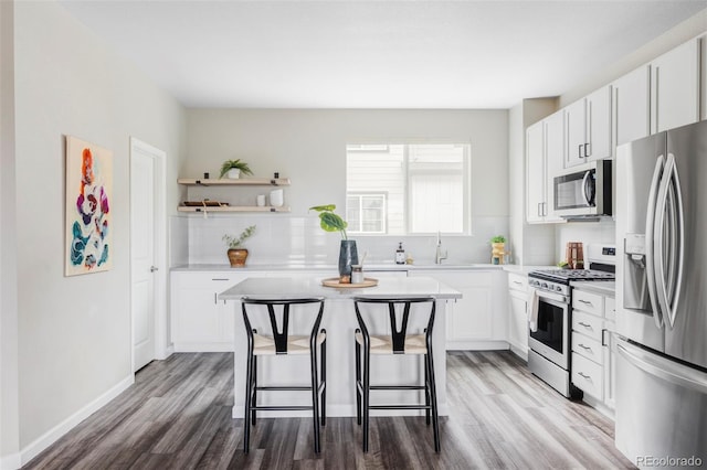 9490 W 14th Ave Unit 3, Lakewood, CO 80215 - kitchen featuring appliances with stainless steel finishes, wood finished floors, light countertops, and white cabinets