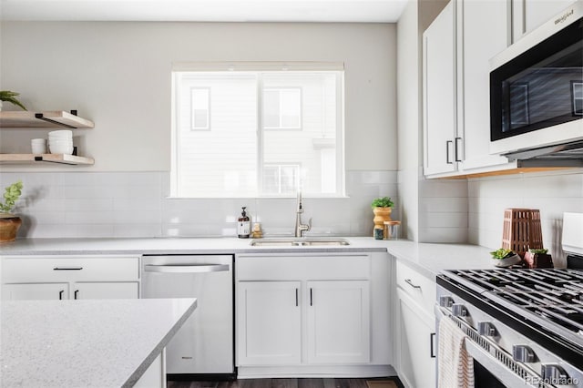 9490 W 14th Ave Unit 3, Lakewood, CO 80215 - kitchen featuring stainless steel appliances, a sink, white cabinetry, and tasteful backsplash