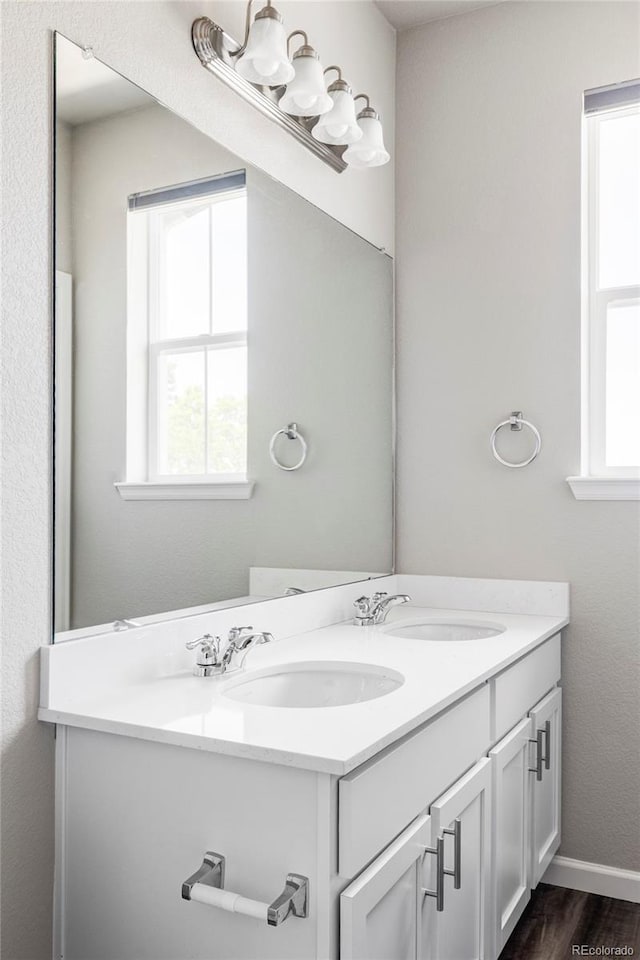 9490 W 14th Ave Unit 3, Lakewood, CO 80215 - bathroom featuring double vanity, wood finished floors, and baseboards