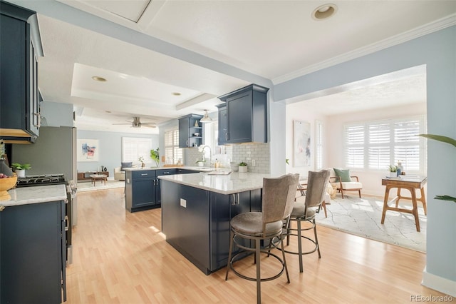 kitchen with a breakfast bar, light wood-style floors, a peninsula, and open shelves