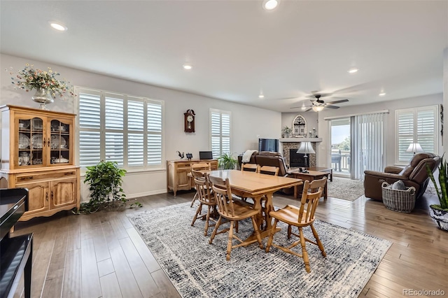 15211 Quince St, Thornton, CO 80602 - dining space featuring a fireplace, a ceiling fan, recessed lighting, wood-type flooring, and baseboards