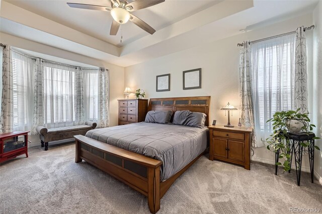 15211 Quince St, Thornton, CO 80602 - bedroom featuring light carpet, a tray ceiling, baseboards, and a ceiling fan