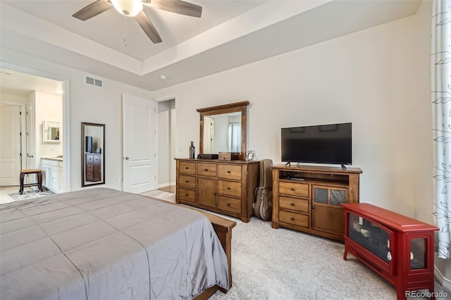 15211 Quince St, Thornton, CO 80602 - bedroom featuring a wood stove, light colored carpet, a raised ceiling, a ceiling fan, and connected bathroom