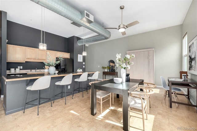 2501 15th St Unit 2C, Denver, CO 80211 - kitchen with black fridge, light brown cabinetry, light countertops, a sink, and a kitchen breakfast bar