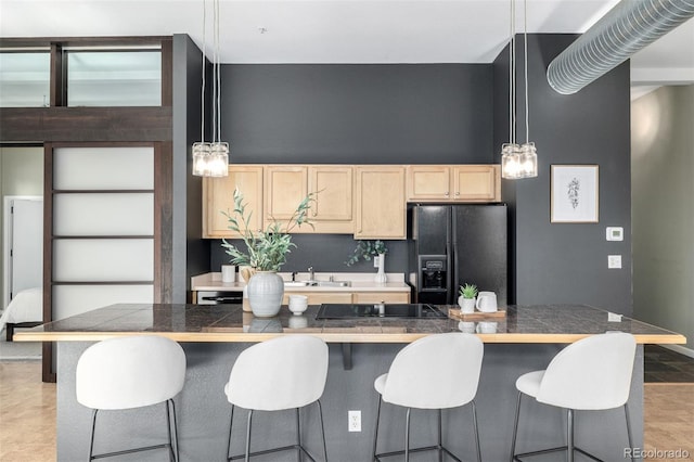 2501 15th St Unit 2C, Denver, CO 80211 - kitchen with black appliances, light brown cabinets, a sink, a breakfast bar, and hanging light fixtures