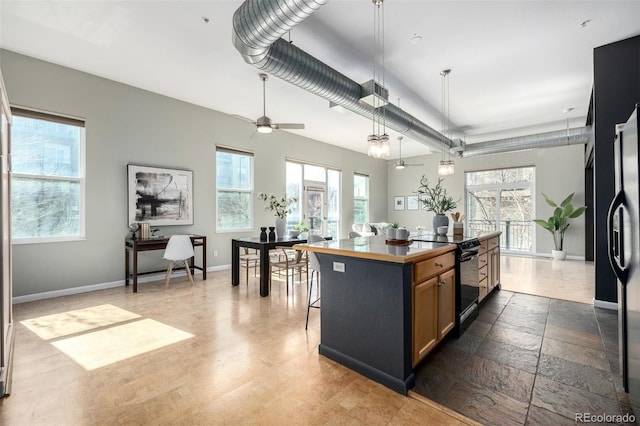 2501 15th St Unit 2C, Denver, CO 80211 - kitchen with a kitchen island, a desk, black appliances, a ceiling fan, and a kitchen breakfast bar