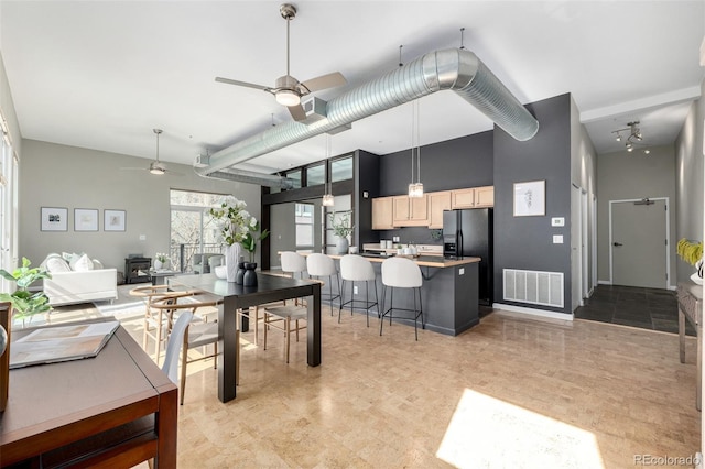 2501 15th St Unit 2C, Denver, CO 80211 - kitchen with light brown cabinets, ceiling fan, a high ceiling, black fridge with ice dispenser, and a breakfast bar