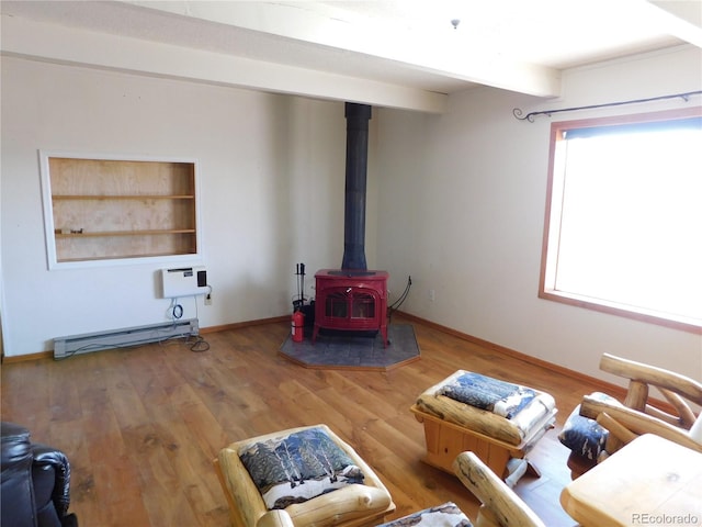 11003 US Highway 160, Del Norte, CO 81132 - living area featuring a wood stove, wood finished floors, baseboards, and a baseboard heating unit