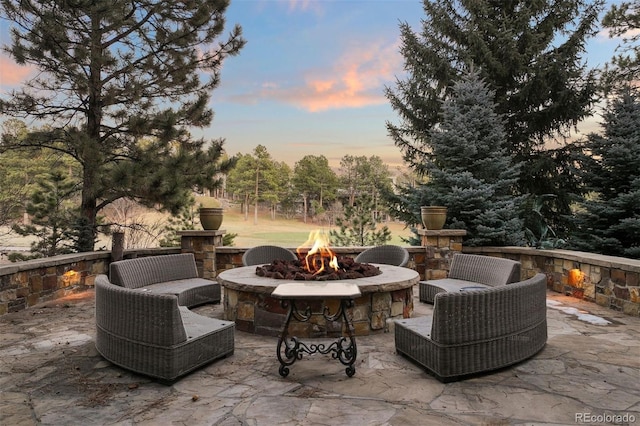 patio terrace at dusk with an outdoor living space with a fire pit