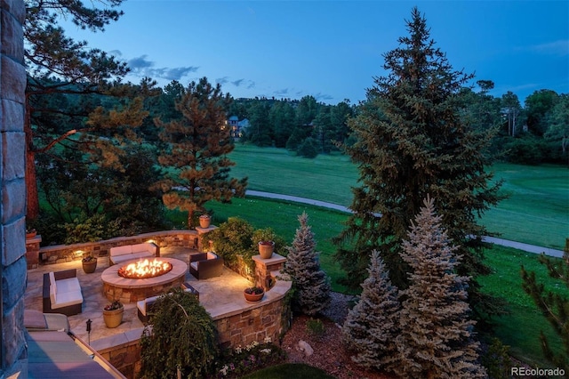 patio terrace at dusk with a yard and an outdoor fire pit