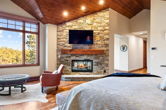 bedroom featuring lofted ceiling, wood finished floors, baseboards, wood ceiling, and a fireplace