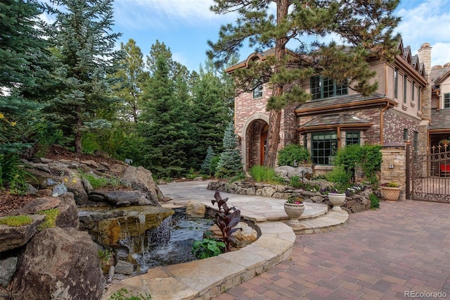exterior space featuring a gate and a small pond