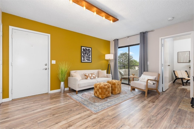 1820 Newland Ct Unit 310, Lakewood, CO 80214 - living area with light wood finished floors, baseboards, and a textured ceiling
