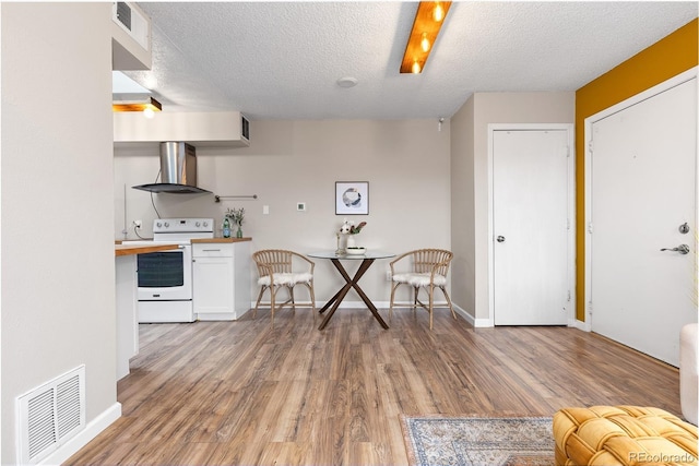1820 Newland Ct Unit 310, Lakewood, CO 80214 - kitchen featuring wall chimney exhaust hood, white electric range oven, light wood-type flooring, a textured ceiling, and white cabinetry