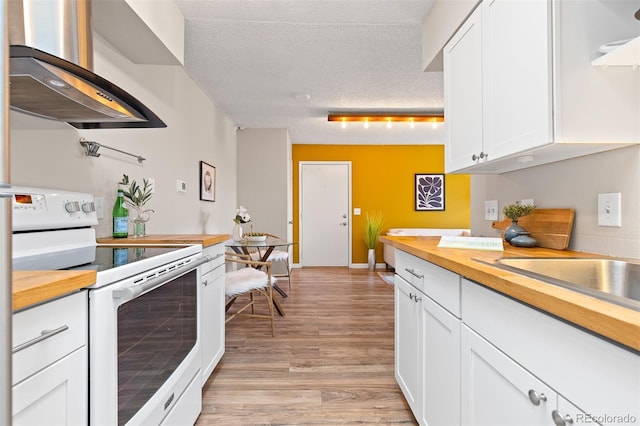 1820 Newland Ct Unit 310, Lakewood, CO 80214 - kitchen featuring white electric range oven, butcher block counters, wall chimney range hood, a textured ceiling, and white cabinetry