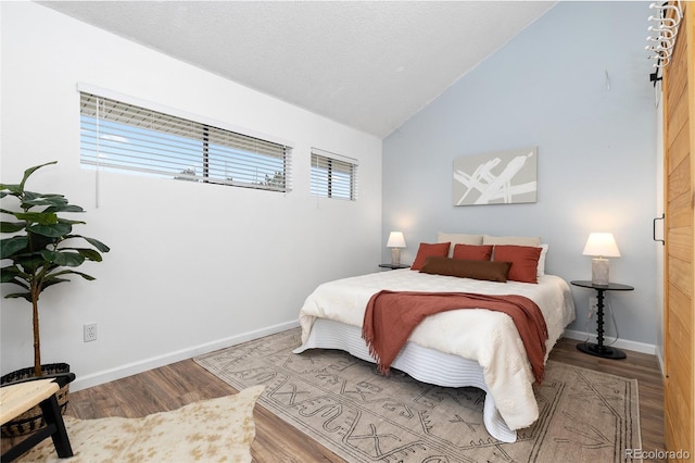 1820 Newland Ct Unit 310, Lakewood, CO 80214 - bedroom featuring wood finished floors, lofted ceiling, and baseboards