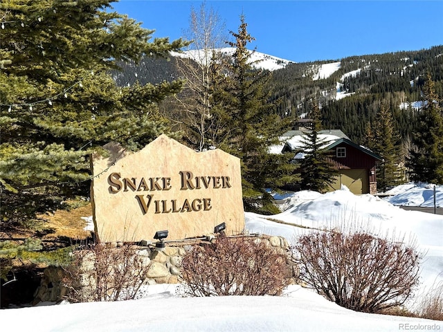 community sign featuring a wooded view