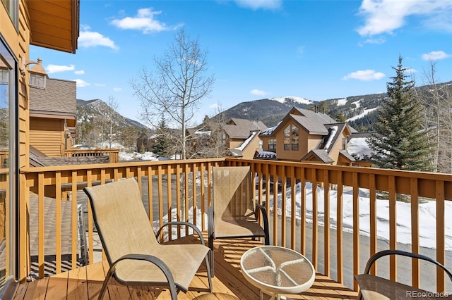 snow covered deck with a mountain view