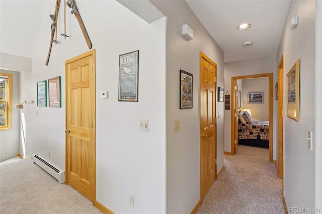 hall with baseboard heating and light carpet