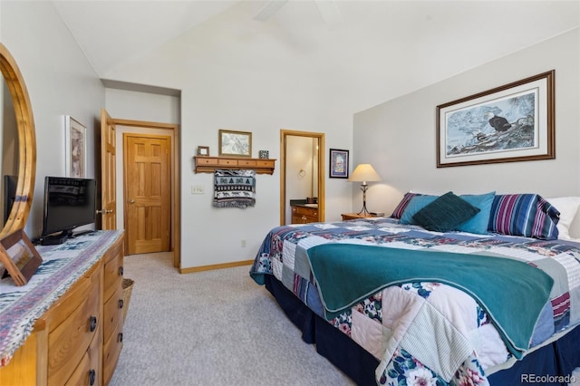 bedroom with light colored carpet, ensuite bath, baseboards, and vaulted ceiling