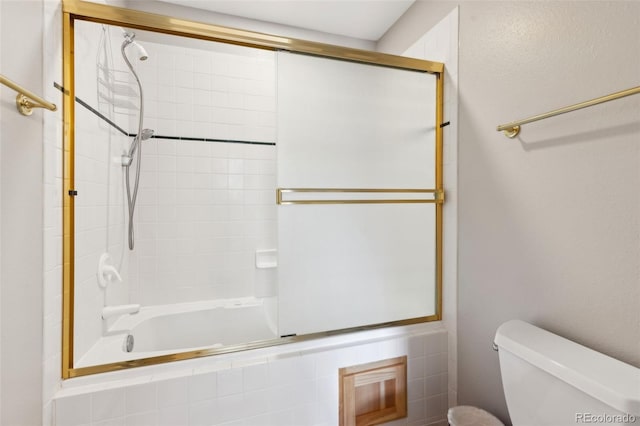 bathroom featuring toilet and tiled shower / bath