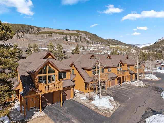 snowy aerial view featuring a residential view and a mountain view