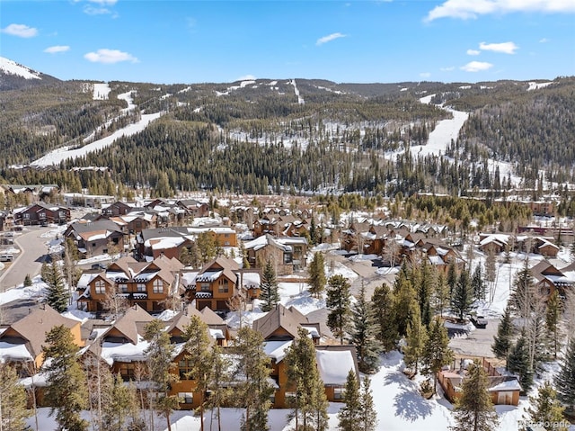 snowy aerial view featuring a mountain view and a residential view