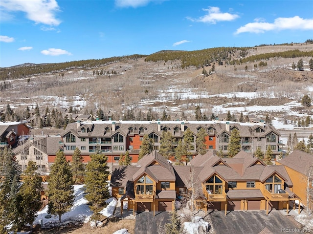 snowy aerial view with a residential view and a mountain view