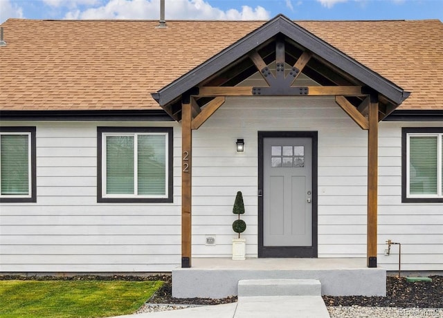 property entrance featuring a shingled roof and a porch