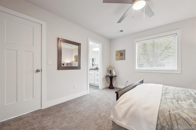 bedroom with connected bathroom, carpet flooring, baseboards, visible vents, and ceiling fan